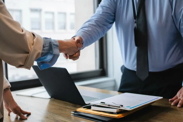 Employer shaking an employees hand and promising him a secure job.